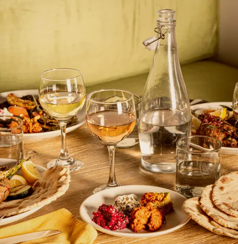 A beautifully arranged table featuring dishes, drinks, and appetizers, creating an inviting dining experience.