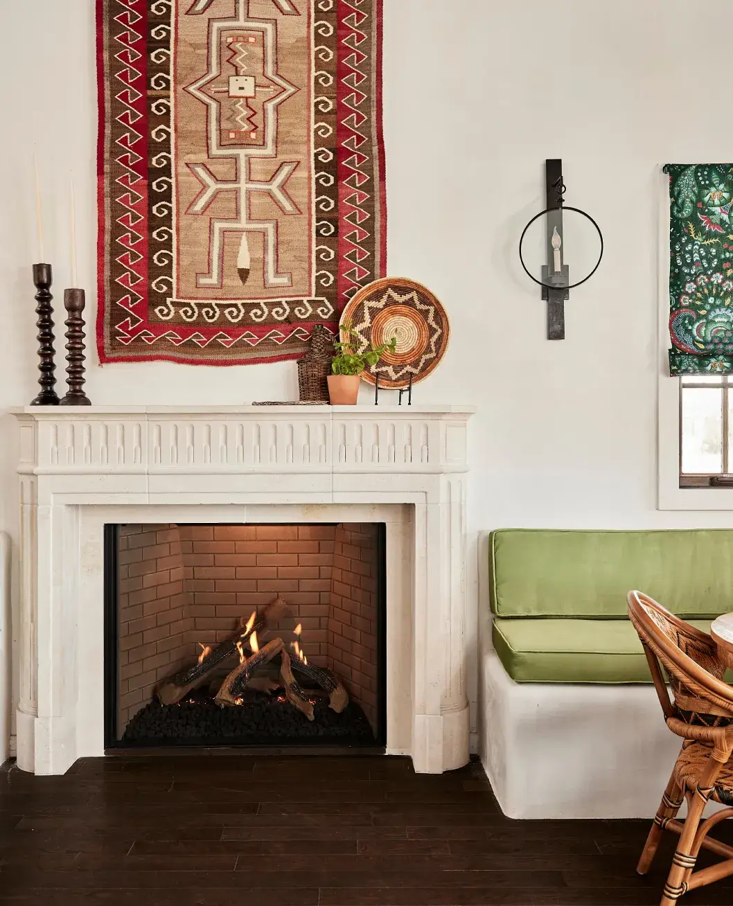 Cozy living space featuring a fireplace, colorful textiles, and a green seating area, enhancing warmth and style.